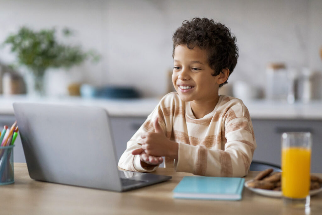 happy black boy interacting with laptop while sitt 2024 03 12 00 48 46 utc